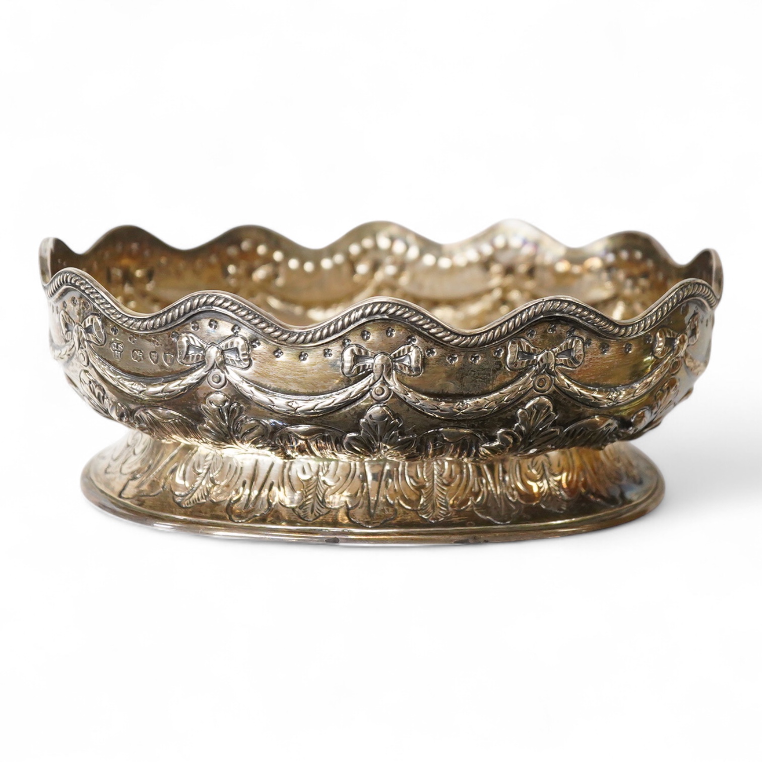 A late Victorian embossed silver oval bowl, by Charles Stuart Harris, with engraved initials to the base, London, 1890, length 16.4cm, 7.3oz.